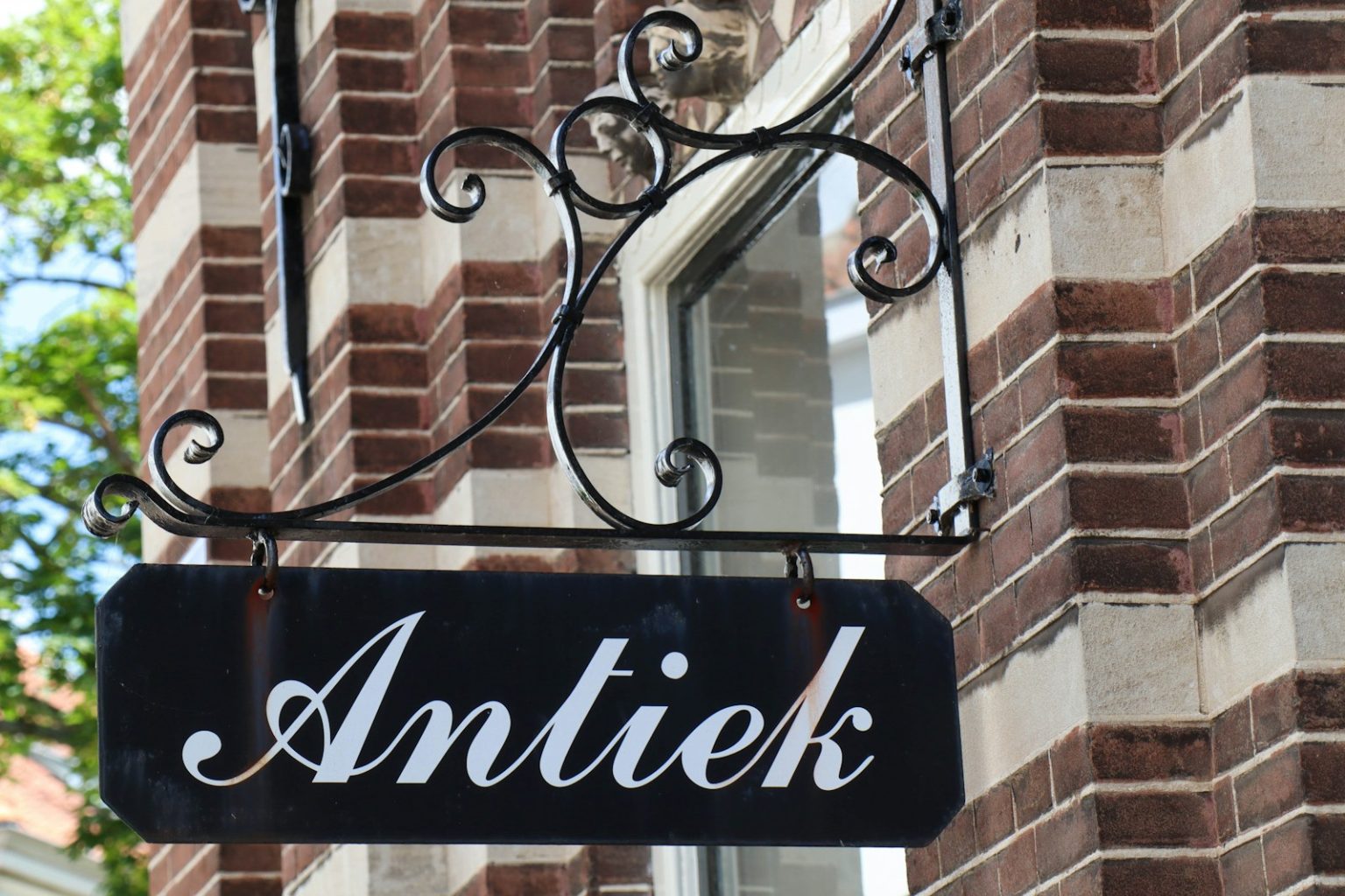 a black and white sign hanging from the side of a building